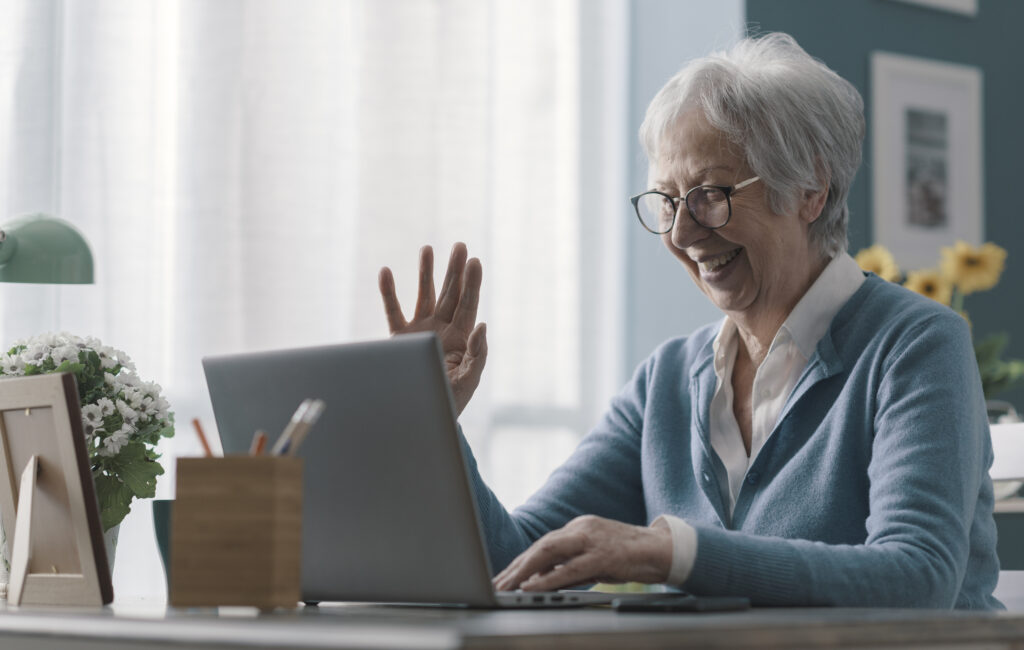 Woman happily talking to someone on laptop video call